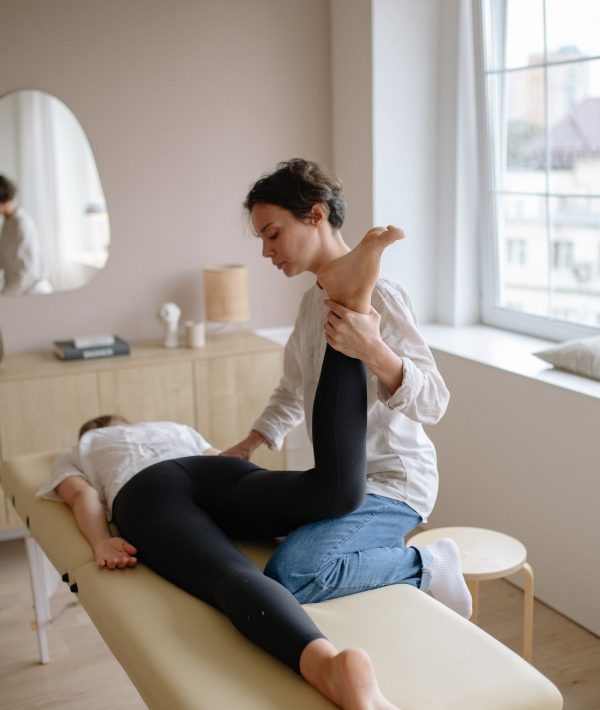 canva-physiotherapist-holding-patients-leg-MAEMl_zT2ak